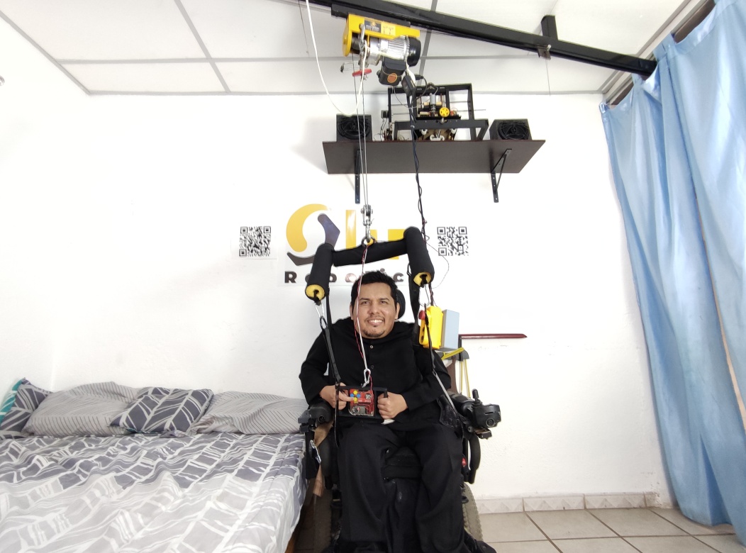 Una persona utilizando una grúa para traslado de una silla de ruedas a la cama de forma independiente